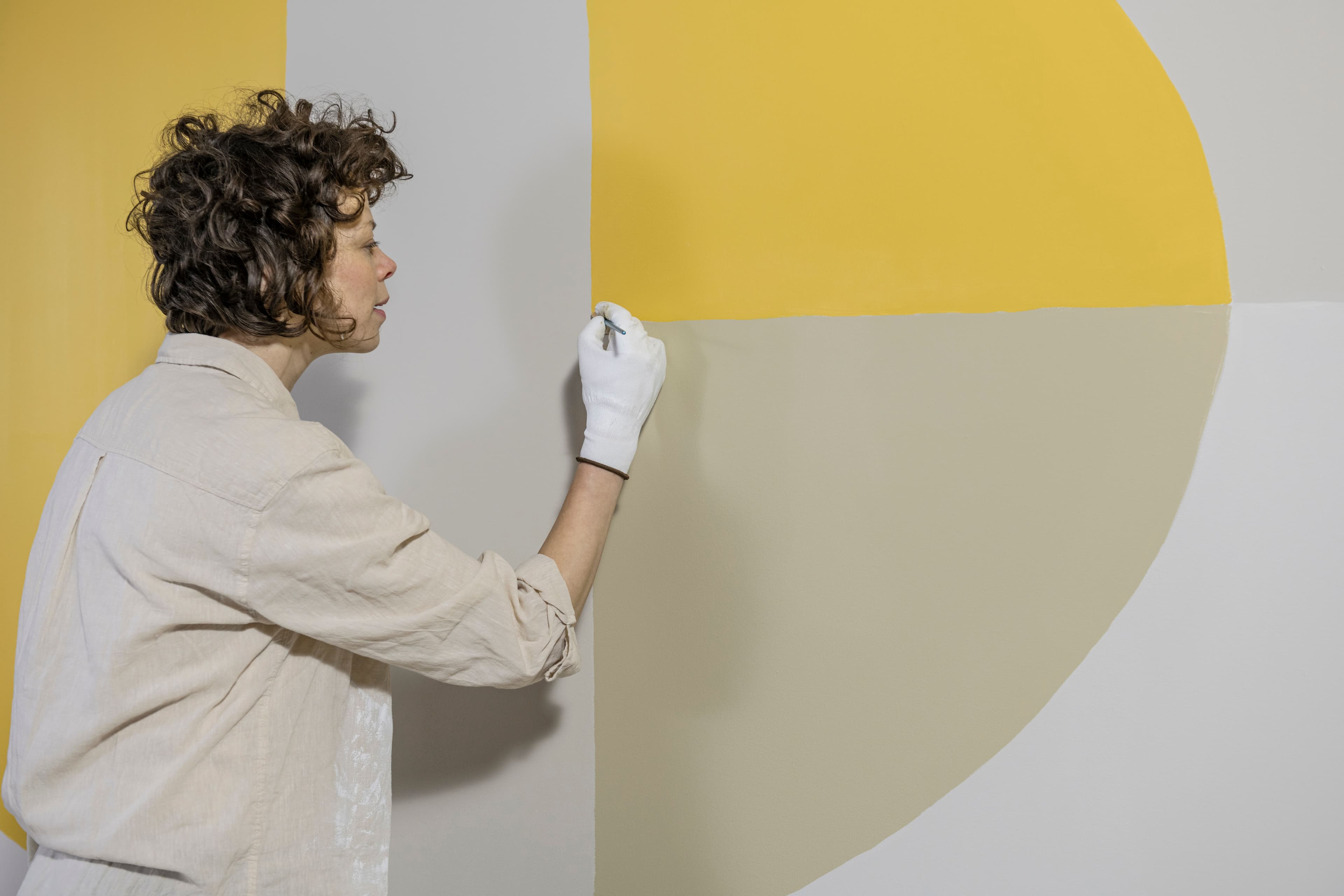 Someone applying the finishing touch to a free-form shape with a smaller paint brush